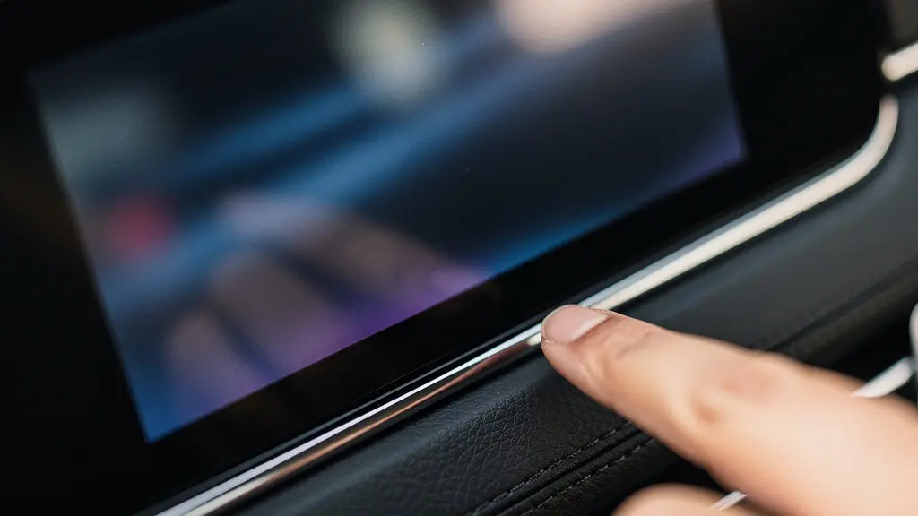 Gros plan sur un écran multimédia automobile moderne avec reflets de lumière, symbolisant l'importance de la connectivité smartphone pour la valeur de revente